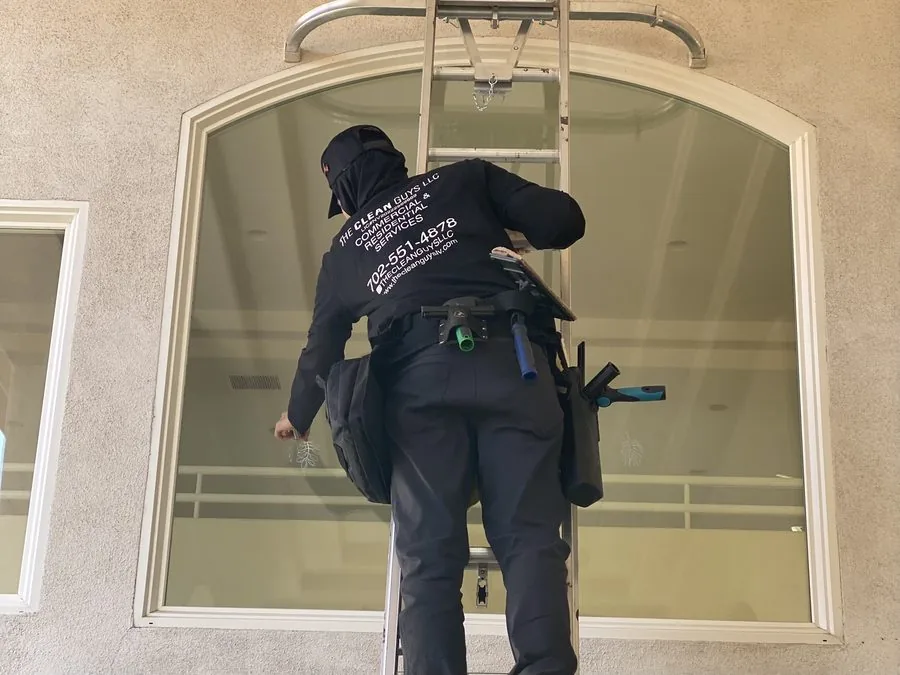 The Clean Guys team member on ladder cleaning high windows Las Vegas